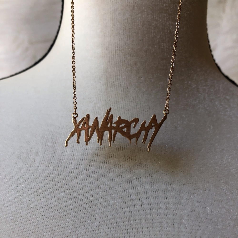 Gold “ANARCHY” dripped written necklace.